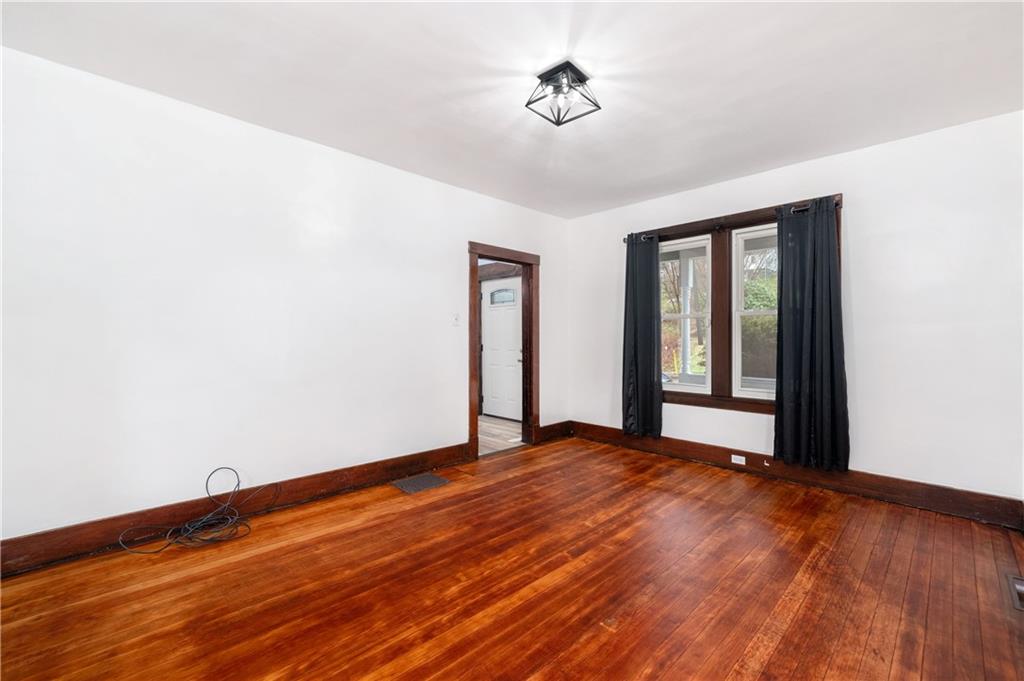 140 Whitestown Road Lyndora, PA 16045 - Photo 7 of 29 a view of an empty room with wooden floor and a window