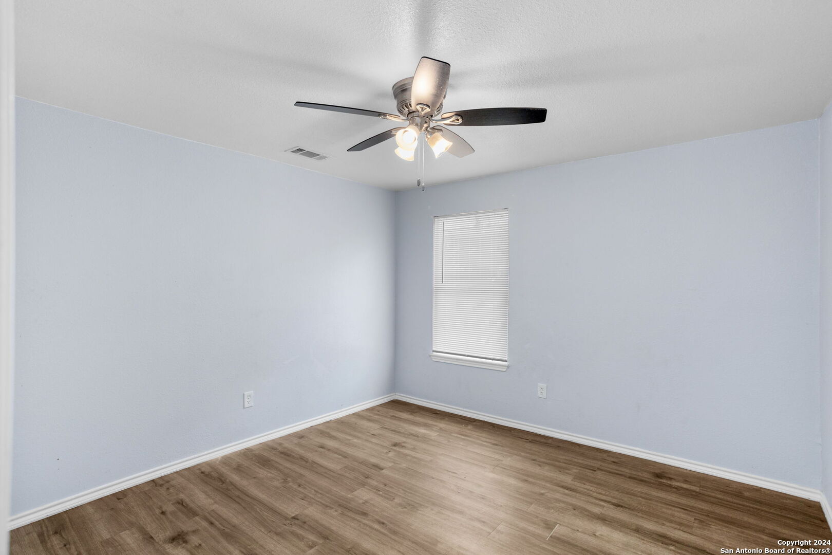 113 Vista Road San Antonio, TX 78210 - Photo 10 of 17 an empty room with wooden floor fan and windows