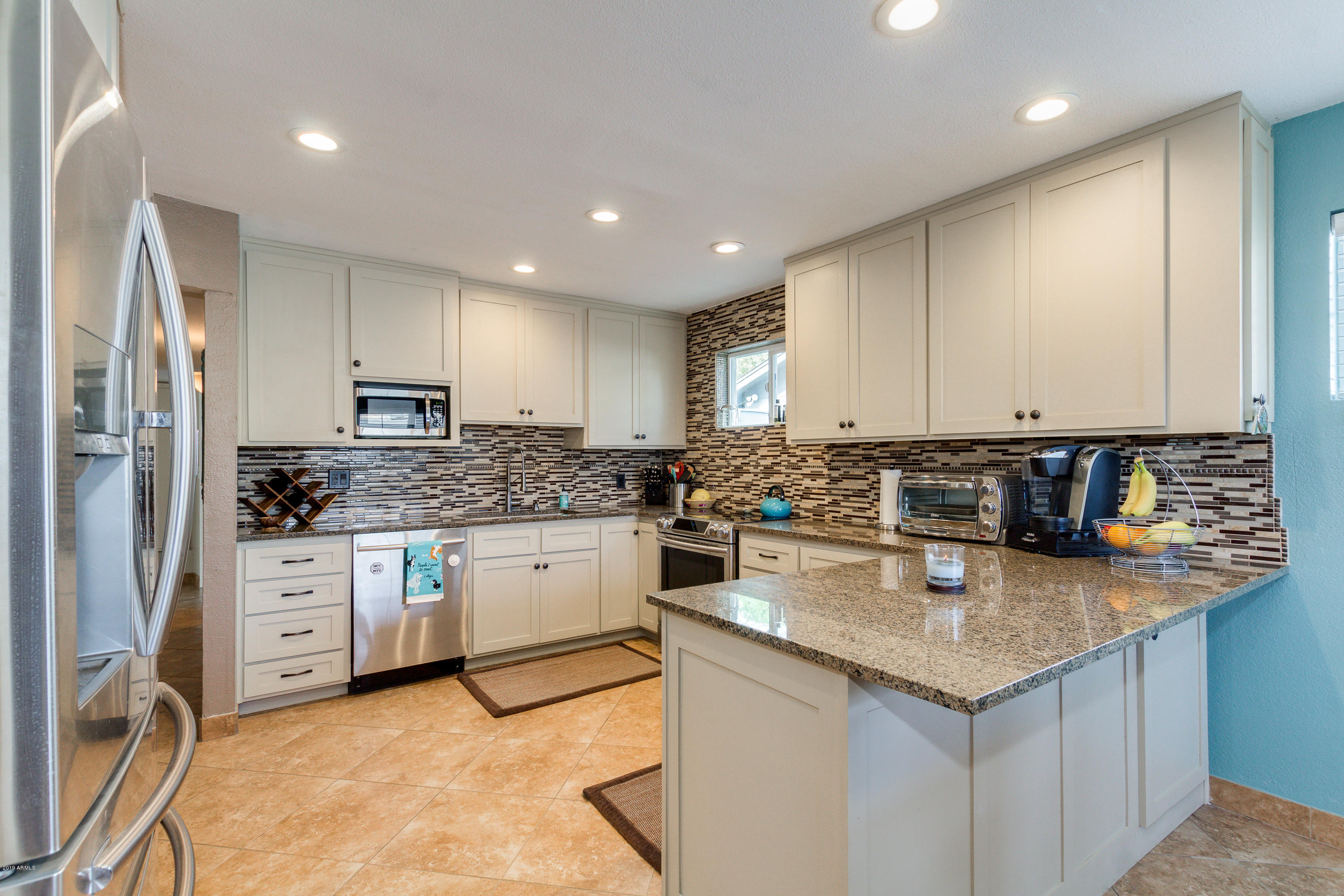 3021 West Bloomfield Road Phoenix, AZ 85029 - Photo 1 of 27 a kitchen with kitchen island granite countertop a stove sink and cabinets