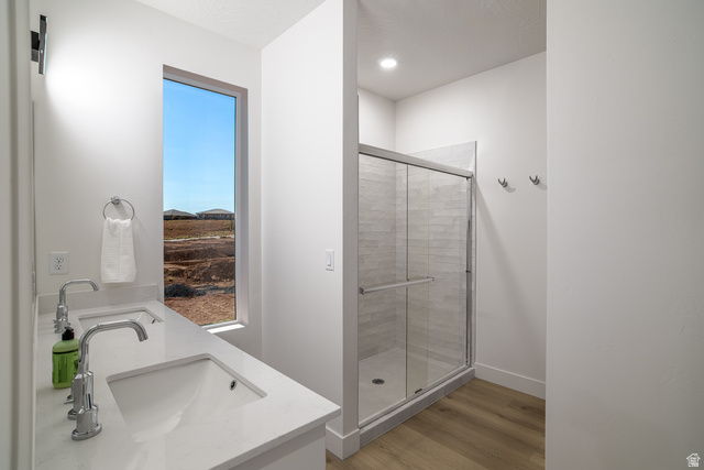 2768 Becco Trail, Unit 63 St. George, UT 84770 - Photo 22 of 27 Full bath with double vanity, light wood-type flooring, and a stall shower