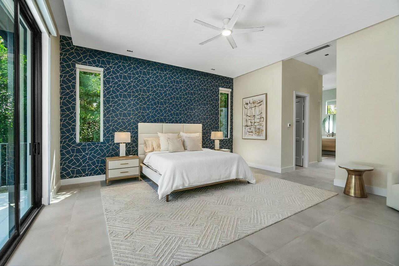 751 Pelican Way North Palm Beach, FL 33408 - Photo 20 of 39 a bedroom with a large bed and a chandelier