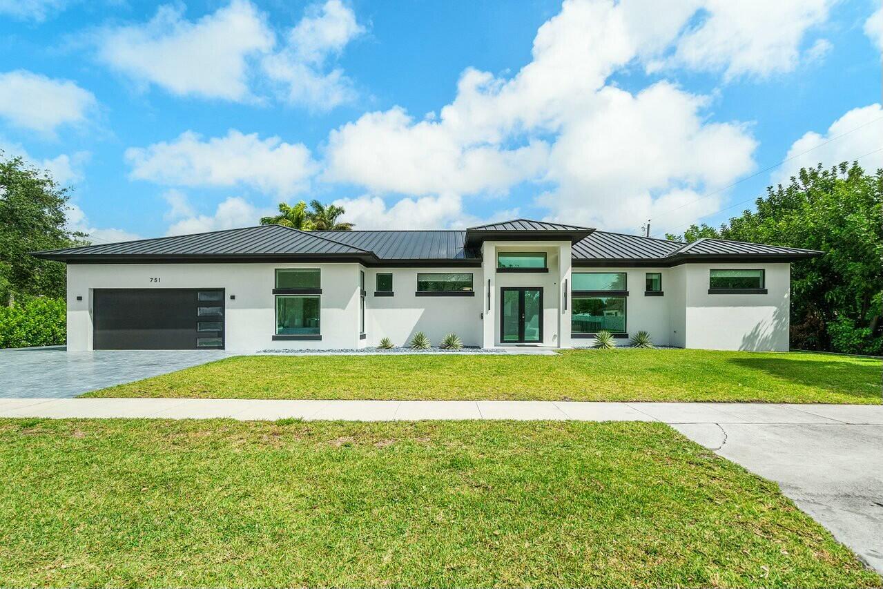 751 Pelican Way North Palm Beach, FL 33408 - Photo 2 of 39 a front view of a house with a garden