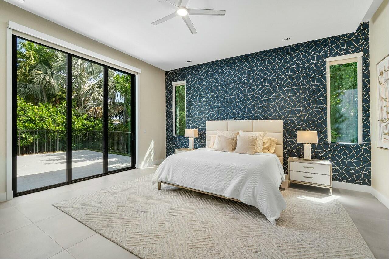 751 Pelican Way North Palm Beach, FL 33408 - Photo 21 of 39 a spacious bedroom with a large bed and a large window