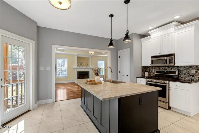 a kitchen with kitchen island granite countertop a sink a counter top space appliances and cabinets