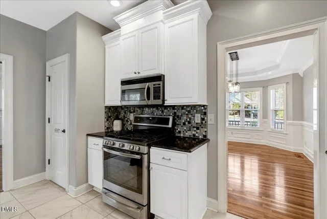 a kitchen with white cabinets and appliances