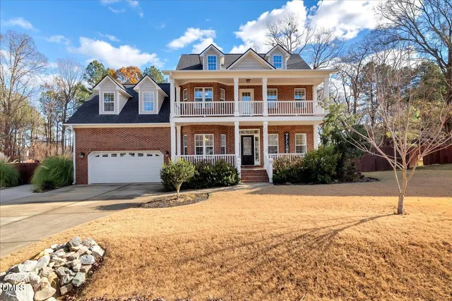 a front view of house with yard and trees around