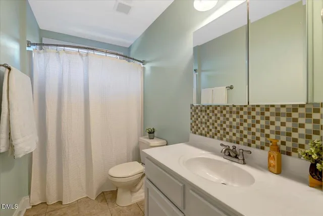 a bathroom with a sink a toilet and shower curtain