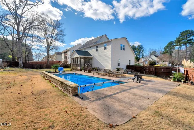 a swimming pool with outdoor seating and yard