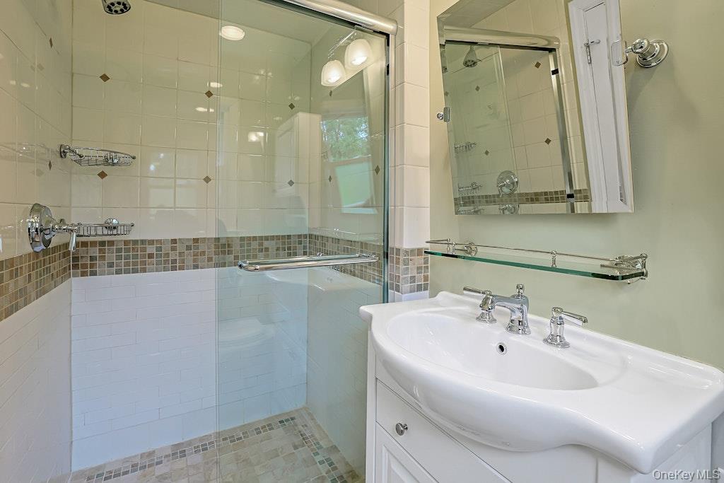 305 Stratton Road New Rochelle, NY 10804 - Photo 16 of 32 a bathroom with a sink a mirror and a shower
