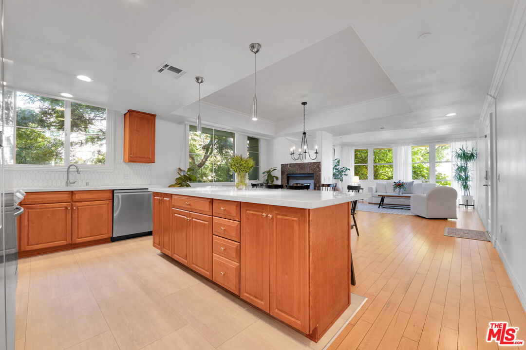 1601 South Bentley Avenue, Unit 201 Los Angeles, CA 90025 - Photo 12 of 39 a large kitchen with stainless steel appliances a large counter top a sink a window and wooden floor