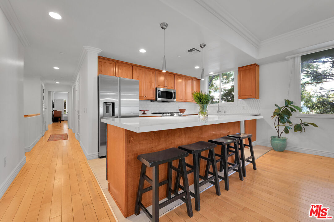 1601 South Bentley Avenue, Unit 201 Los Angeles, CA 90025 - Photo 13 of 39 a large kitchen with a table and chairs in it