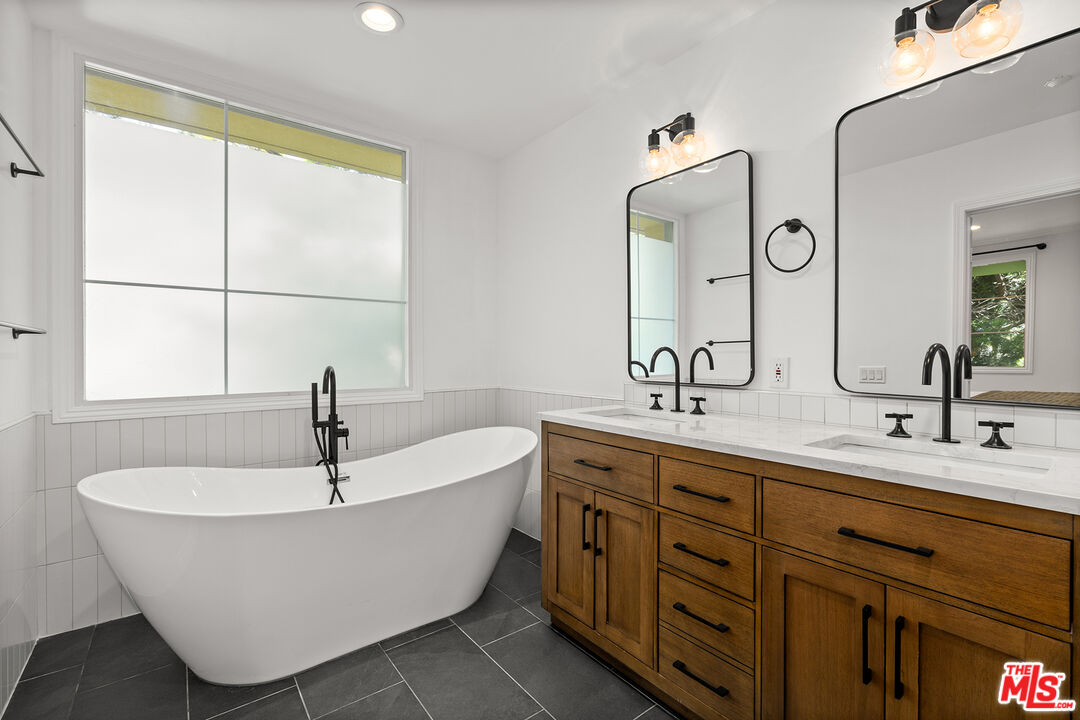 1601 South Bentley Avenue, Unit 201 Los Angeles, CA 90025 - Photo 18 of 39 a bathroom with a tub sink and mirror
