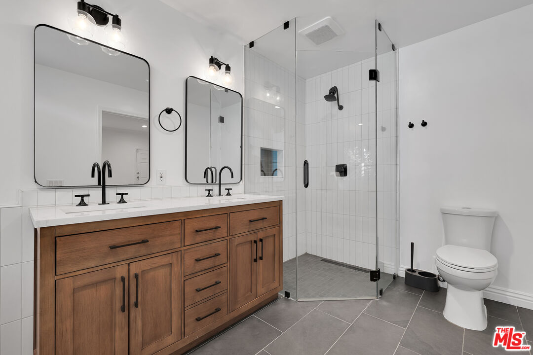 1601 South Bentley Avenue, Unit 201 Los Angeles, CA 90025 - Photo 19 of 39 a spacious bathroom with a double vanity sink a toilet and a mirror
