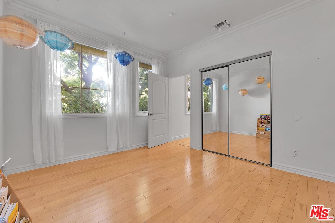 1601 South Bentley Avenue, Unit 201 Los Angeles, CA 90025 - Photo 22 of 39 a view of an empty room with wooden floor and a window