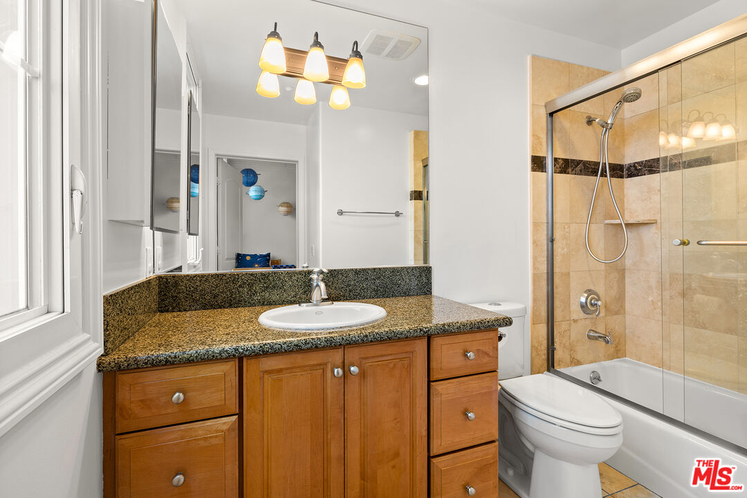1601 South Bentley Avenue, Unit 201 Los Angeles, CA 90025 - Photo 23 of 39 a bathroom with a granite countertop sink toilet and shower