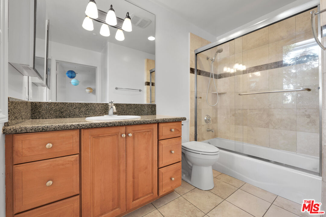1601 South Bentley Avenue, Unit 201 Los Angeles, CA 90025 - Photo 27 of 39 a bathroom with a granite countertop sink a toilet and shower