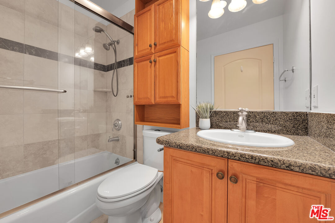 1601 South Bentley Avenue, Unit 201 Los Angeles, CA 90025 - Photo 29 of 39 a bathroom with a granite countertop sink toilet and shower