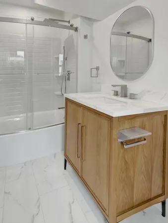 a bathroom with a sink mirror and shower