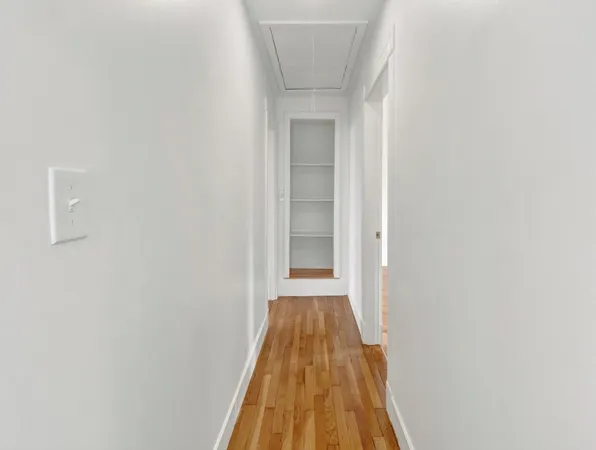 a view of a hallway with wooden floor