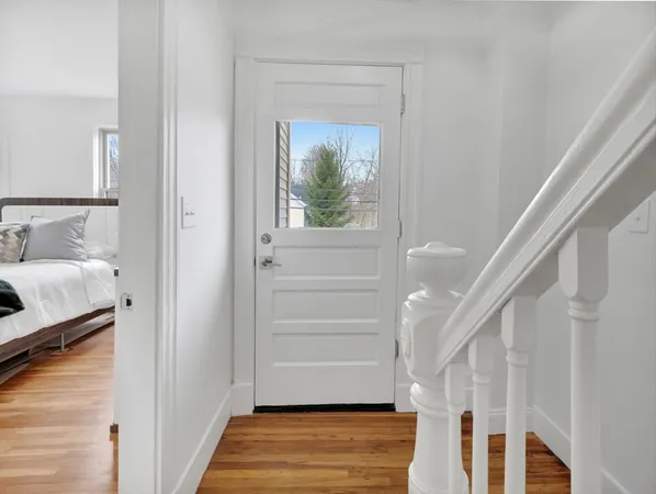 a view of a hallway with wooden floor and staircase