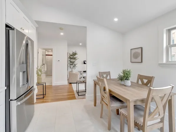 a kitchen with stainless steel appliances refrigerator dining table and chairs