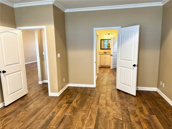 a view of a hallway with wooden floor and front door