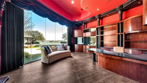 a living room with furniture a floor to ceiling window and kitchen view
