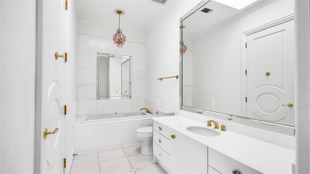 1400 Copper Point Drive Prosper, TX 75078 - Photo 30 of 39 a bathroom with a sink vanity granite tub and a mirror