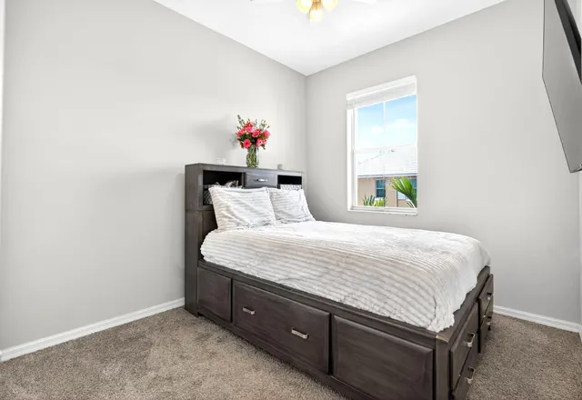 a bed sitting in a bedroom next to a window
