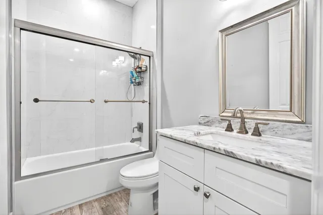 a bathroom with a granite countertop sink toilet and shower