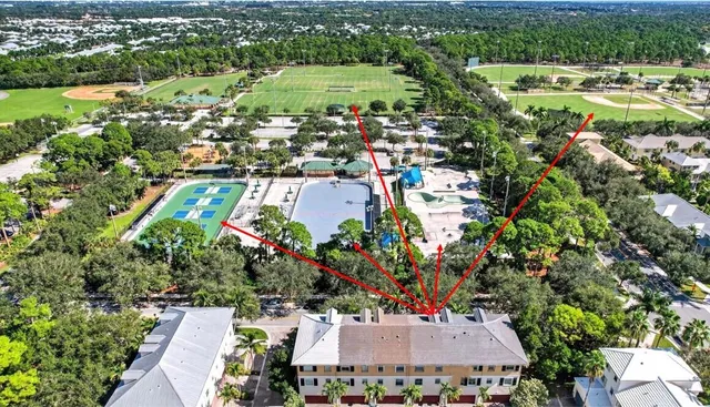 an aerial view of residential houses with outdoor space and trees
