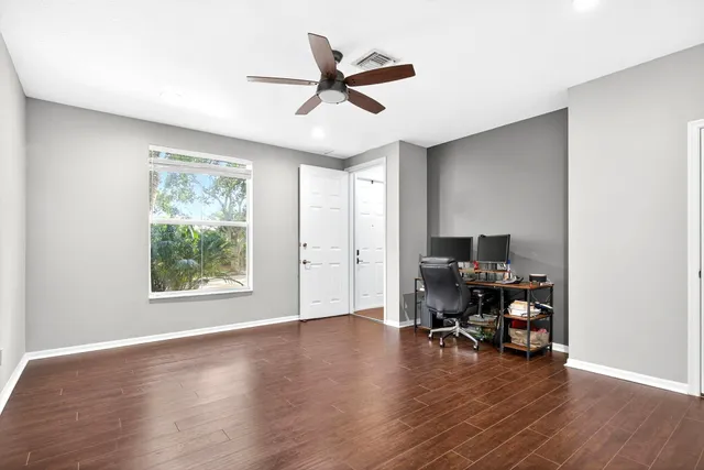a view of a workspace with wooden floor and a window