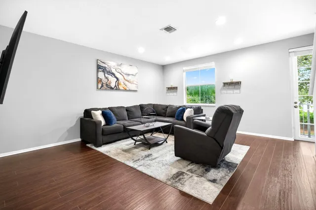 a living room with furniture window and wooden floor