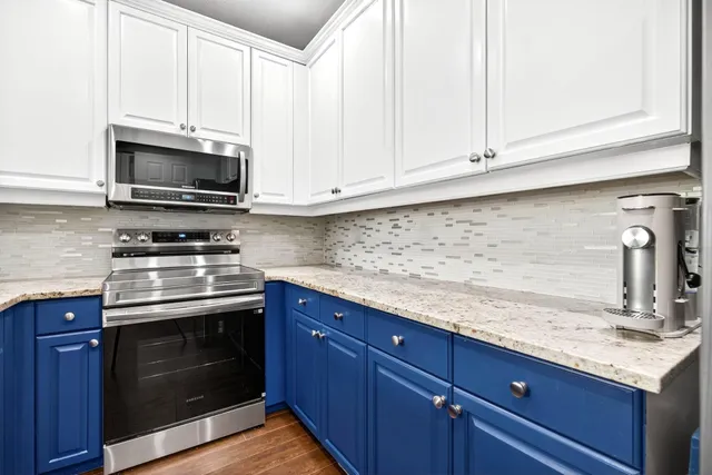 a kitchen with granite countertop a sink stove and microwave