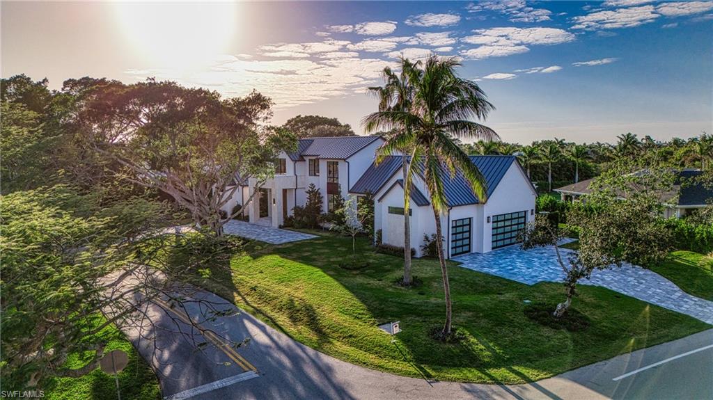 721 Springline Drive Naples, FL 34102 - Photo 47 of 50 a front view of a house with a yard and potted plants