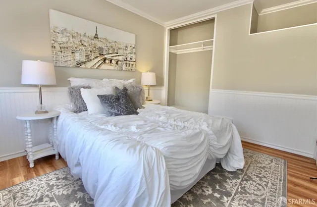 a bedroom with a bed and a lamp on the dresser