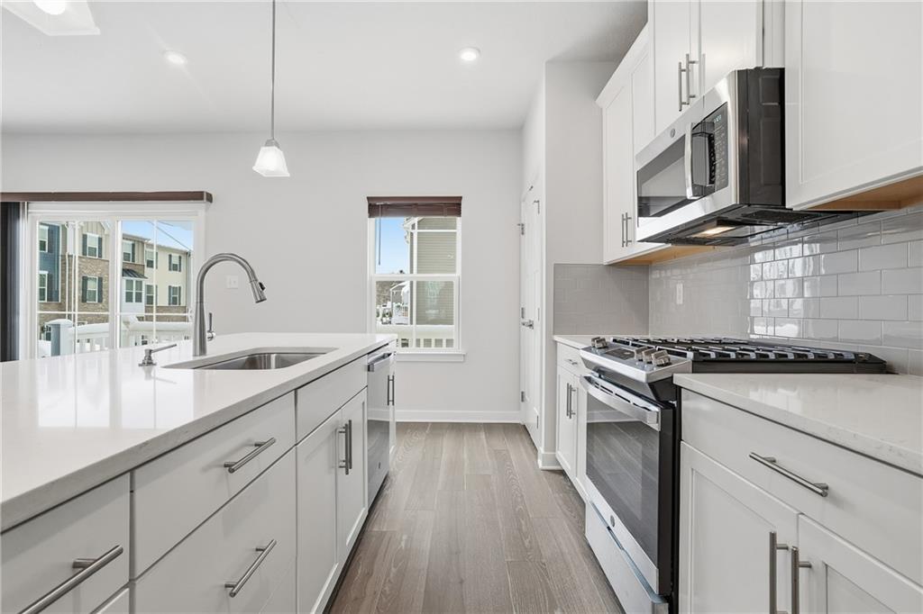 9002 Hickory Road Gibsonia, PA 15044 - Photo 13 of 46 a kitchen with stainless steel appliances granite countertop a sink a stove and a wooden floors