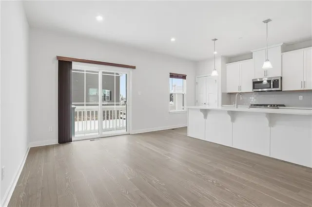 a view of kitchen with wooden floor and electronic appliances