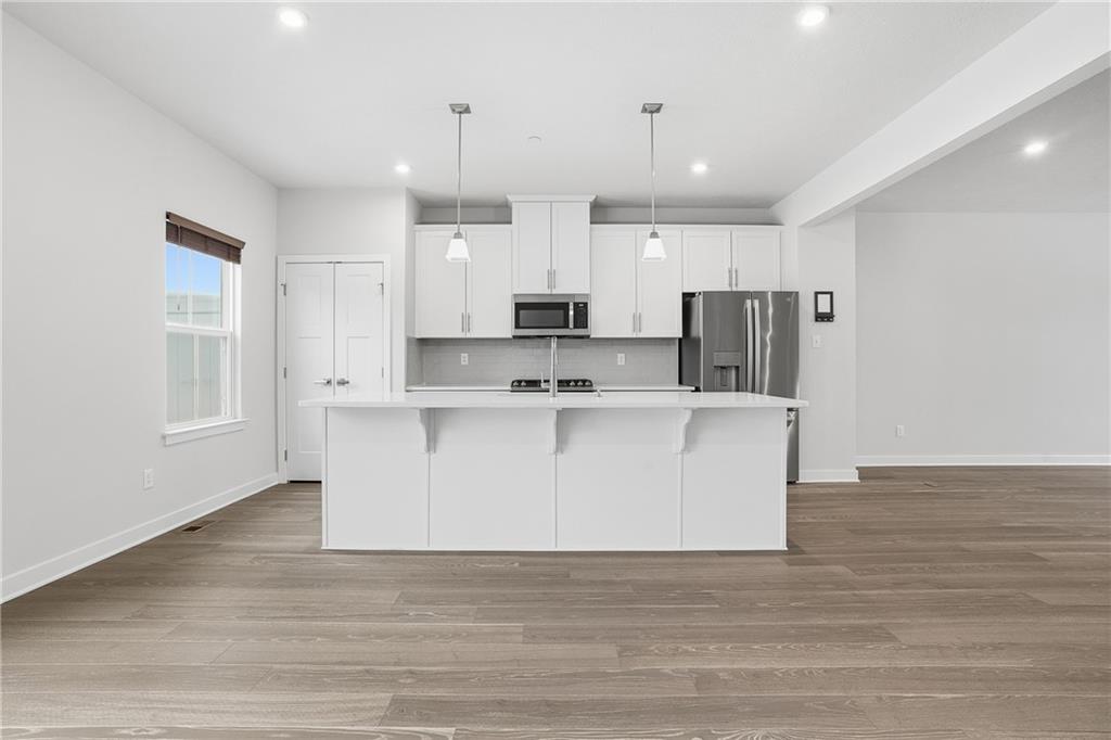 9002 Hickory Road Gibsonia, PA 15044 - Photo 7 of 46 a view living room with stainless steel appliances kitchen island granite countertop a refrigerator a stove a sink and white cabinets with wooden floor