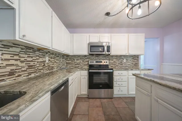 a kitchen with stainless steel appliances granite countertop a stove and a sink