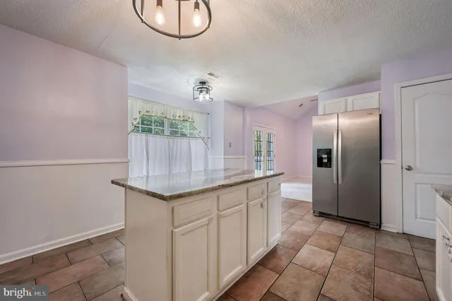 a kitchen with stainless steel appliances granite countertop a sink and a refrigerator