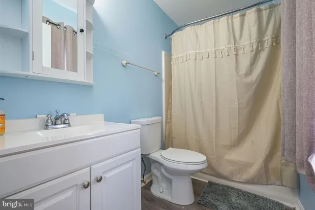 a bathroom with a white sink toilet and shower