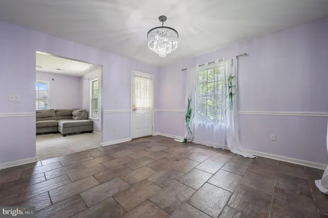 a view of a livingroom with a window and a kitchen