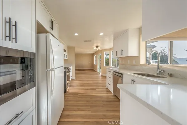 a large kitchen with granite countertop a large counter top stainless steel appliances and a window