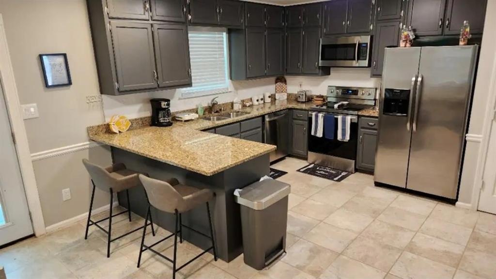 20 Fair Forest Terrace Covington, GA 30016 - Photo 6 of 19 a kitchen with stainless steel appliances granite countertop a sink a stove a microwave a counter top space and cabinets