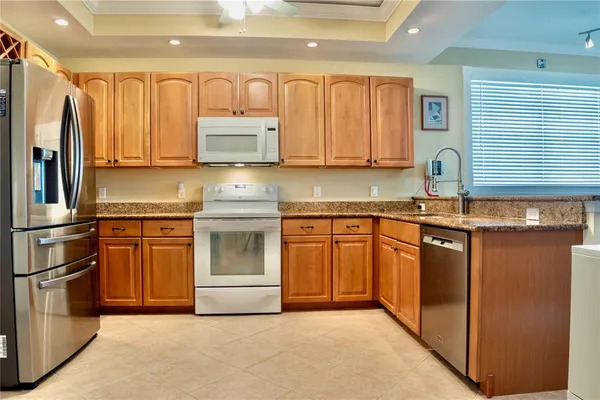 a kitchen with stainless steel appliances granite countertop a sink refrigerator stove and microwave