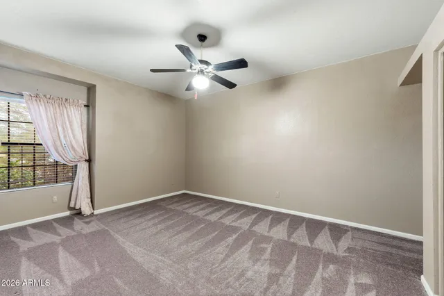 an empty room with closet and windows