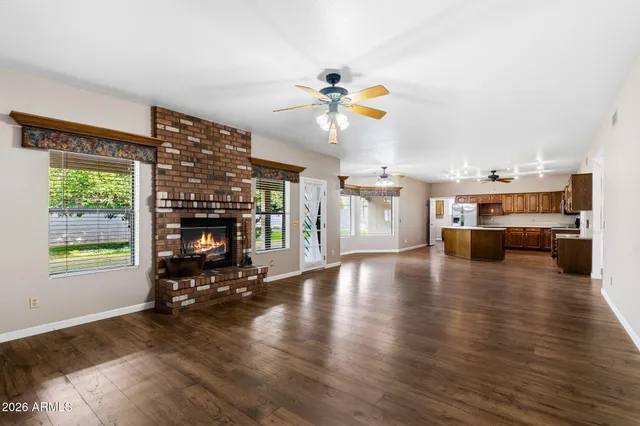 a view of a livingroom with furniture a fireplace and wooden floor