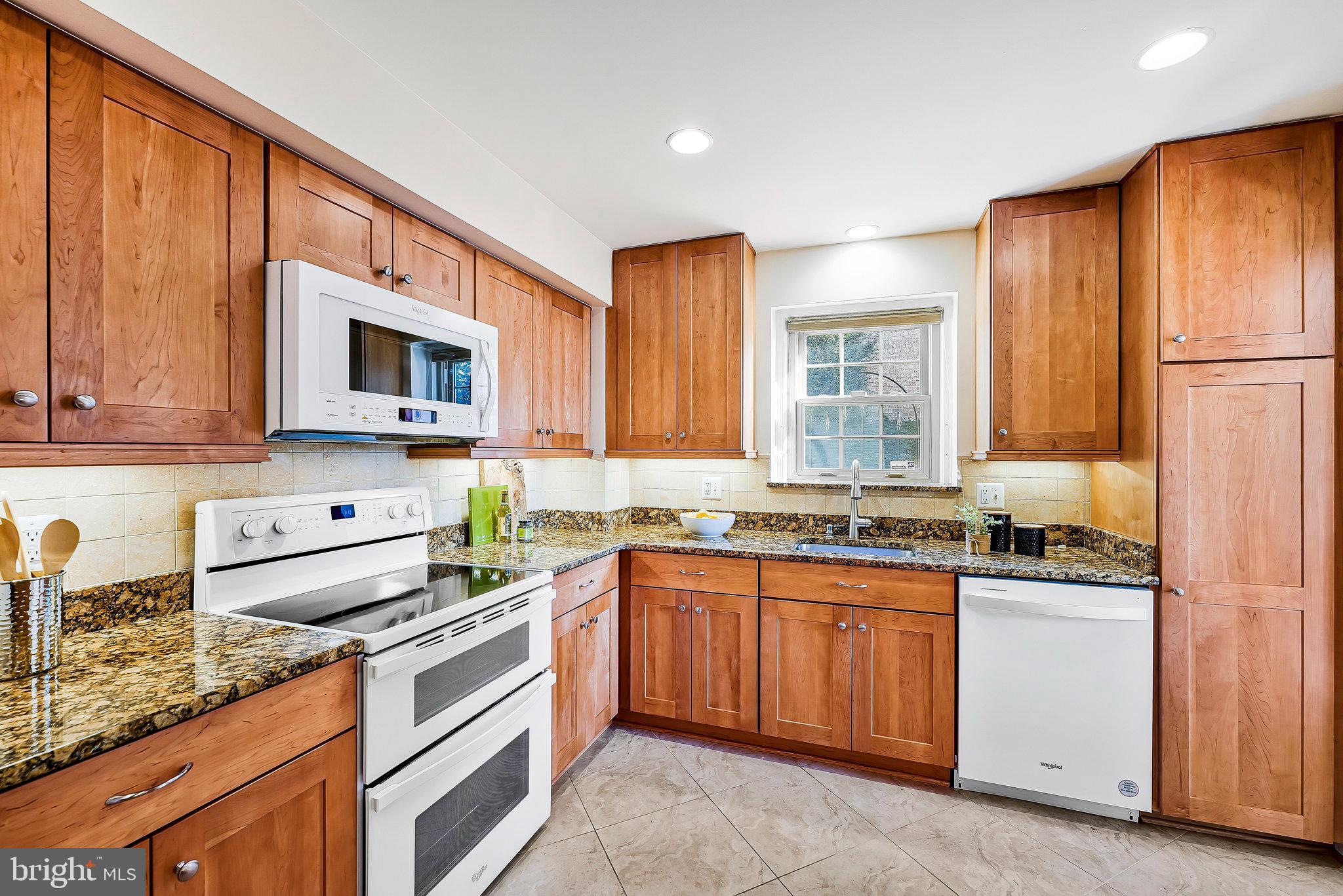7346 Eldorado Street McLean, VA 22102 - Photo 17 of 48 a kitchen with stainless steel appliances granite countertop wooden cabinets stove a sink and dishwasher