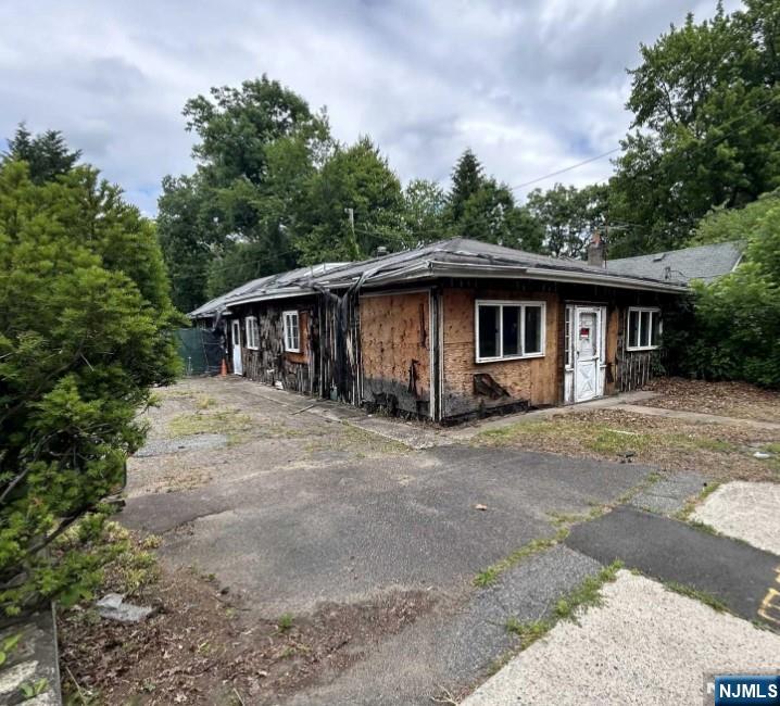 a front view of a house with a garden and trees